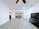 Open-concept living room features tile flooring, access to the sunroom, and views into the kitchen at 5806 Liverpool Dr, Tampa, FL 33615