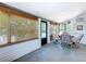 Enclosed sunroom features a glass table with seating, tile flooring, and many windows for natural light at 5806 Liverpool Dr, Tampa, FL 33615