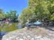 Waterfront lot with mature trees and water access, perfect for relaxing outdoors on a clear sunny day at 5806 Liverpool Dr, Tampa, FL 33615