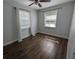 Bedroom with dark wood floors, light grey walls, and natural lighting from two large windows at 627 Riverside Dr, Tarpon Springs, FL 34689