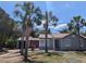 Charming single-story home with palm trees in the front yard at 627 Riverside Dr, Tarpon Springs, FL 34689