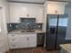 Updated kitchen features stainless steel appliances, white cabinets, and stylish backsplash at 627 Riverside Dr, Tarpon Springs, FL 34689