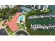 Stunning aerial view featuring a pool, tennis courts, a boat dock, and lush landscaping at this waterfront community at 7867 Sailboat Key S Blvd # 101, South Pasadena, FL 33707
