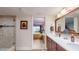 Bathroom with double sinks, granite countertops, and a shower with glass doors, plus a view into the bedroom at 7867 Sailboat Key S Blvd # 101, South Pasadena, FL 33707