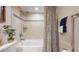 Tiled bathroom with a shower and tub combination, featuring neutral color scheme and decorative accents at 7867 Sailboat Key S Blvd # 101, South Pasadena, FL 33707
