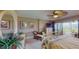 Bedroom featuring fan, view of the lanai, tropical themed bedspread, and an adjoining bathroom at 7867 Sailboat Key S Blvd # 101, South Pasadena, FL 33707