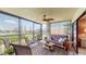 Enclosed sunroom with lake views, comfortable seating, and a decorative ceiling fan at 7867 Sailboat Key S Blvd # 101, South Pasadena, FL 33707