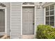 Close-up of the front door, showcasing its classic design and hardware, with a small porch and nearby landscaping at 8101 Interbay Blvd # A, Tampa, FL 33616