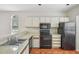Well-lit kitchen offering white cabinets, black appliances, and sleek countertops at 8101 Interbay Blvd # A, Tampa, FL 33616