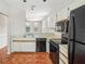 Open kitchen with black appliances, tile floors, and views to living areas through arched windows at 8101 Interbay Blvd # A, Tampa, FL 33616