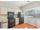 Efficient kitchen with white cabinetry, and black appliances, with a tile floor, and bright bay window at 8101 Interbay Blvd # A, Tampa, FL 33616