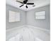 Bedroom with windows, ceiling fan, and tile floor offers ample space and natural light at 8240 Quail Rd, Seminole, FL 33777
