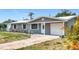 Charming single-story home featuring a brick walkway, covered entry, and well-maintained landscaping at 8240 Quail Rd, Seminole, FL 33777