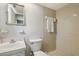 A neutral bathroom featuring a walk-in shower with beige tile, a sink, and a toilet at 8330 Moulton Dr, Port Richey, FL 34668