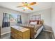 A well-lit bedroom with a full-sized bed, dresser, gray walls, and large windows at 8330 Moulton Dr, Port Richey, FL 34668