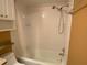 Bathroom features a tub with shower, white tile, and built-in shelving for storage at 845 S Gulfview Blvd # 107, Clearwater Beach, FL 33767