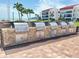 Community grill area with stone surround and multiple stainless steel grills for residents' use at 845 S Gulfview Blvd # 107, Clearwater Beach, FL 33767