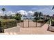 Community pool area is surrounded by lush landscaping and palm trees under a bright blue sky at 845 S Gulfview Blvd # 107, Clearwater Beach, FL 33767
