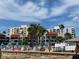 Beautiful condo community pool with many people relaxing under the Florida sun with palm trees and blue skies at 845 S Gulfview Blvd # 107, Clearwater Beach, FL 33767