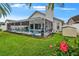 Inviting backyard featuring a screened-in pool and lush landscaping with a small storage shed at 8915 Hannigan Ct, Tampa, FL 33626