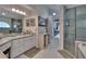 Bathroom featuring double vanity with marble countertops, tile flooring, and a walk-in shower at 8915 Hannigan Ct, Tampa, FL 33626