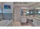 Well-appointed bathroom featuring a soaking tub, vanity with countertop, and decorative mirrors at 8915 Hannigan Ct, Tampa, FL 33626