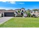 Beautiful home featuring an attached garage and a well-manicured lawn with elegant landscaping at 8915 Hannigan Ct, Tampa, FL 33626
