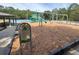 Brightly colored playground equipment sits on a wood chip surface, with picnic tables and a tennis court in the background at 8915 Hannigan Ct, Tampa, FL 33626