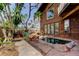 Wooden home exterior, showing access to a unique rock-lined pool and lush landscaping at 919 Sandpiper S Way, St Petersburg, FL 33707
