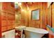 A cozy bathroom boasts warm wood paneling, a vintage sink, and a clawfoot tub at 919 Sandpiper S Way, St Petersburg, FL 33707