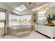 Luxurious bathroom with a corner tub, large windows, and stylish vanity with sink at 919 Sandpiper S Way, St Petersburg, FL 33707
