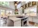 Spacious kitchen boasts an island cooktop, white cabinets, and a dining area, perfect for culinary enthusiasts at 919 Sandpiper S Way, St Petersburg, FL 33707