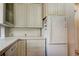 Kitchen featuring white cabinets, tiled countertops, and modern appliances, complemented by ample storage at 919 Sandpiper S Way, St Petersburg, FL 33707