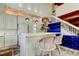 Kitchen island with wicker stools, decorative pendant lights, and white cabinets, offering a cozy and stylish space at 919 Sandpiper S Way, St Petersburg, FL 33707