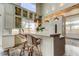 Kitchen with white cabinets, tiled countertops, and decorative pendant lighting over an island with wicker stools at 919 Sandpiper S Way, St Petersburg, FL 33707