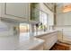 Kitchen featuring white cabinets, white tiled countertops, and a large window for natural light at 919 Sandpiper S Way, St Petersburg, FL 33707