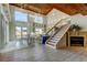 Bright living room featuring high ceilings, wood beams, fireplace, and staircase to the second floor at 919 Sandpiper S Way, St Petersburg, FL 33707