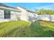 View of backyard with green grass, AC unit, and generator against exterior wall at 11240 Marvelwood, Brooksville, FL 34614