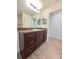 Bathroom featuring wood-look tile flooring, wood vanity, and a large mirror at 11240 Marvelwood, Brooksville, FL 34614
