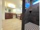 Bright bathroom with wooden cabinets, soaking tub, and walk-in shower with modern black tiling and black and white mosaic floor at 11240 Marvelwood, Brooksville, FL 34614