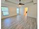 Primary bedroom with tray ceiling, ceiling fan, and light wood-look floors at 11240 Marvelwood, Brooksville, FL 34614