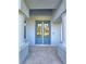 Close-up of the entryway featuring a stylish glass door and neutral-toned pillars at 11240 Marvelwood, Brooksville, FL 34614