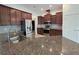 Modern kitchen with stainless steel appliances, dark wood cabinetry, and granite counters at 11240 Marvelwood, Brooksville, FL 34614