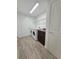 Bright laundry room with wood tile flooring, modern washer and dryer, cabinet and wire shelving at 11240 Marvelwood, Brooksville, FL 34614