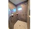 Walk-in shower featuring mosaic tile flooring, stone-look wall tiles, and dual shower heads at 11240 Marvelwood, Brooksville, FL 34614