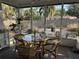 Cozy patio with screened enclosure, perfect for enjoying the outdoors with a glass table and wicker chairs at 11376 119Th Ter, Largo, FL 33778