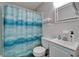 Clean bathroom with toilet, sink, medicine cabinet, decorative shower curtain, and white tiled walls at 126 Ridgewood Ave, Brandon, FL 33510