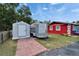 An exterior view of the property, featuring a trailer, a storage unit, and part of the red building at 126 Ridgewood Ave, Brandon, FL 33510
