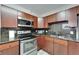 Cozy kitchen featuring wood cabinets, granite countertops, and stainless steel appliances at 126 Ridgewood Ave, Brandon, FL 33510