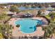 Aerial view of a clover-shaped pool with an ornate brick-paved deck and palm trees at 12831 White Bluff Rd, Hudson, FL 34669